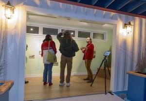 A group of people stand talking inside a shipping container.